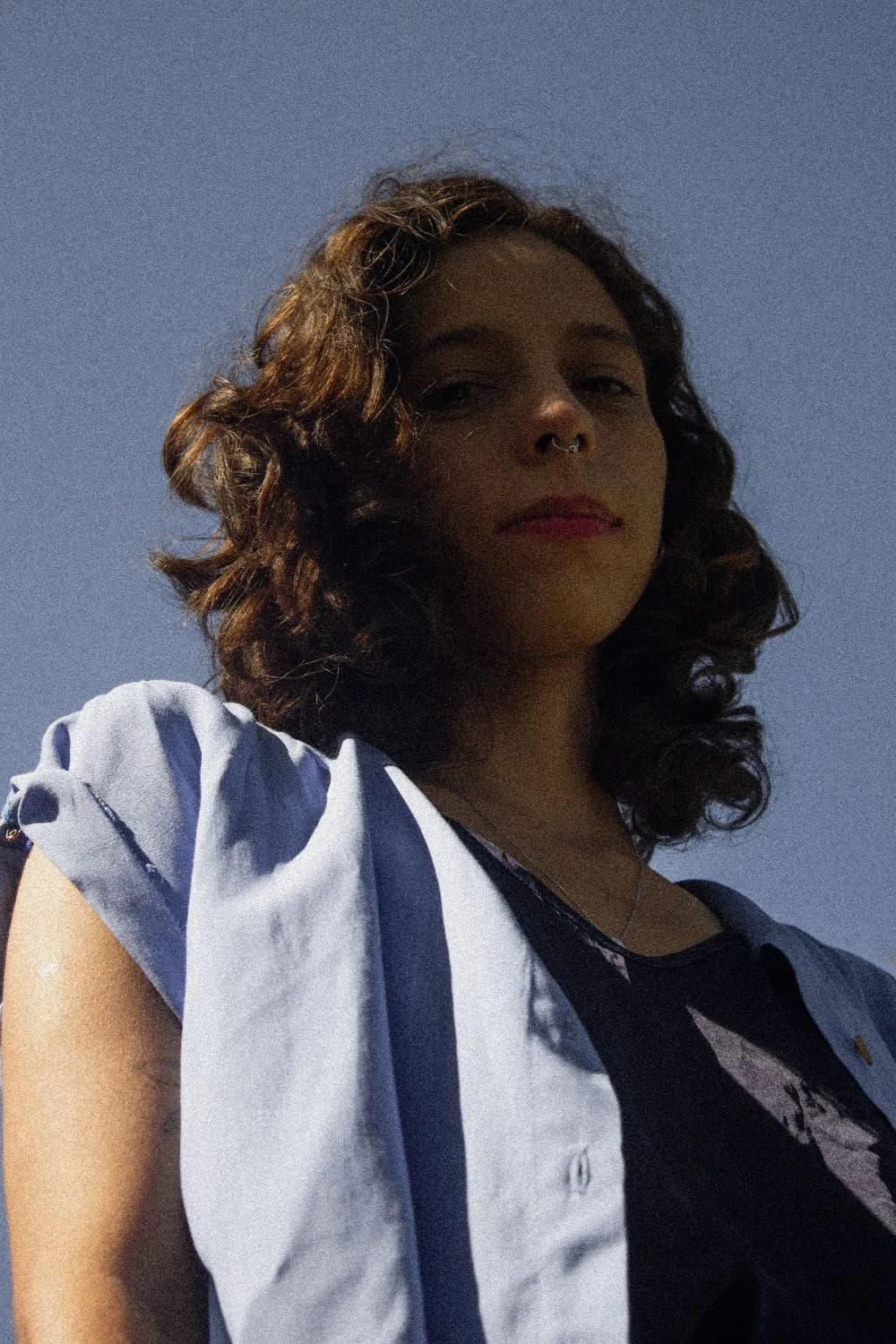 Retrato contra o céu, camisa azul no ombro