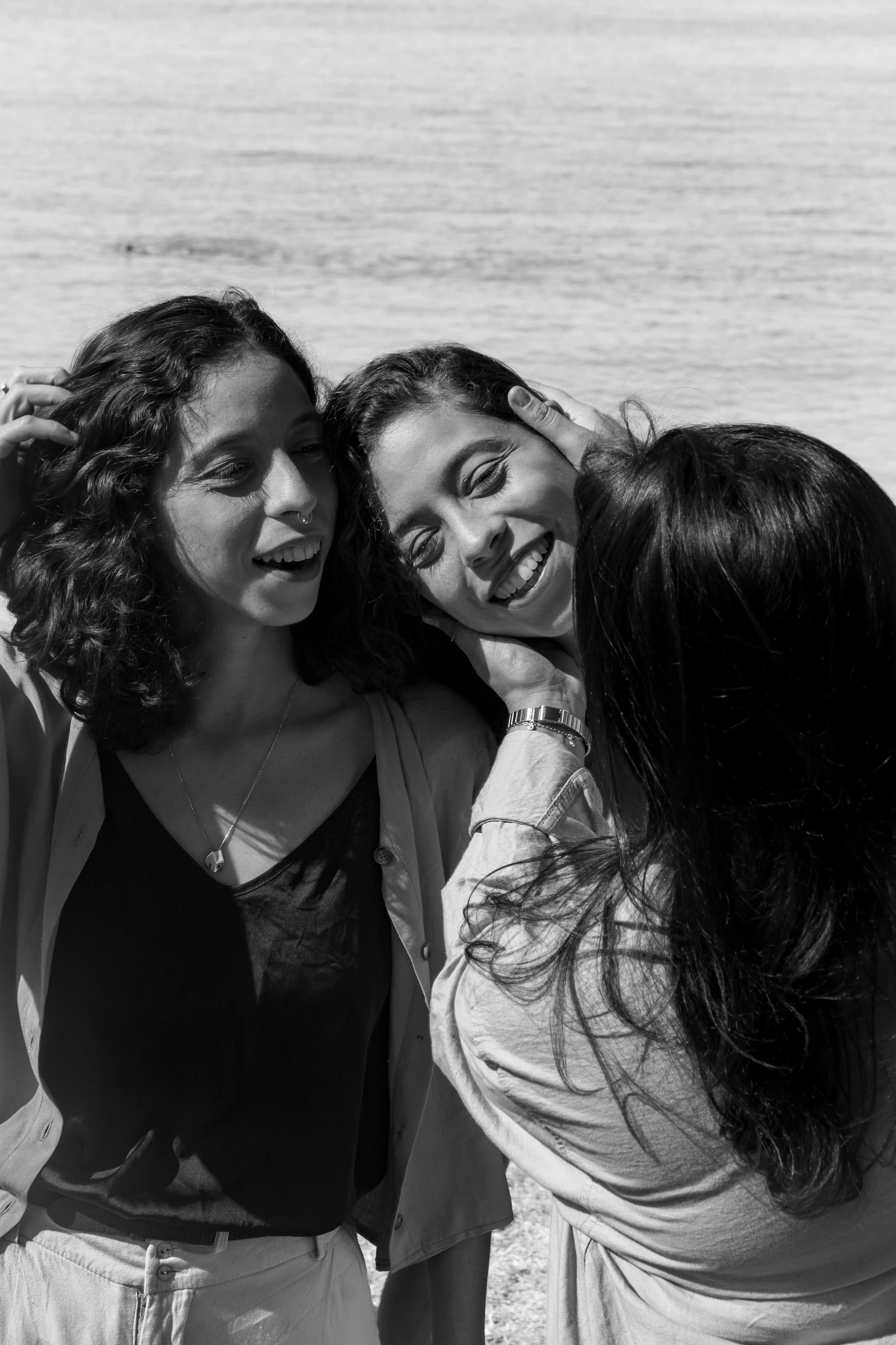 As três integrantes da banda, retrato à beira do mar