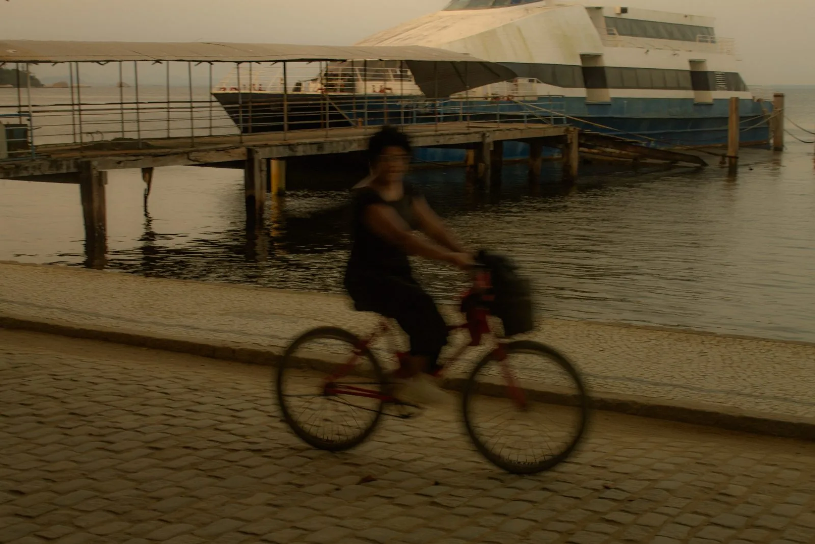 Ciclista na orla junto ao píer