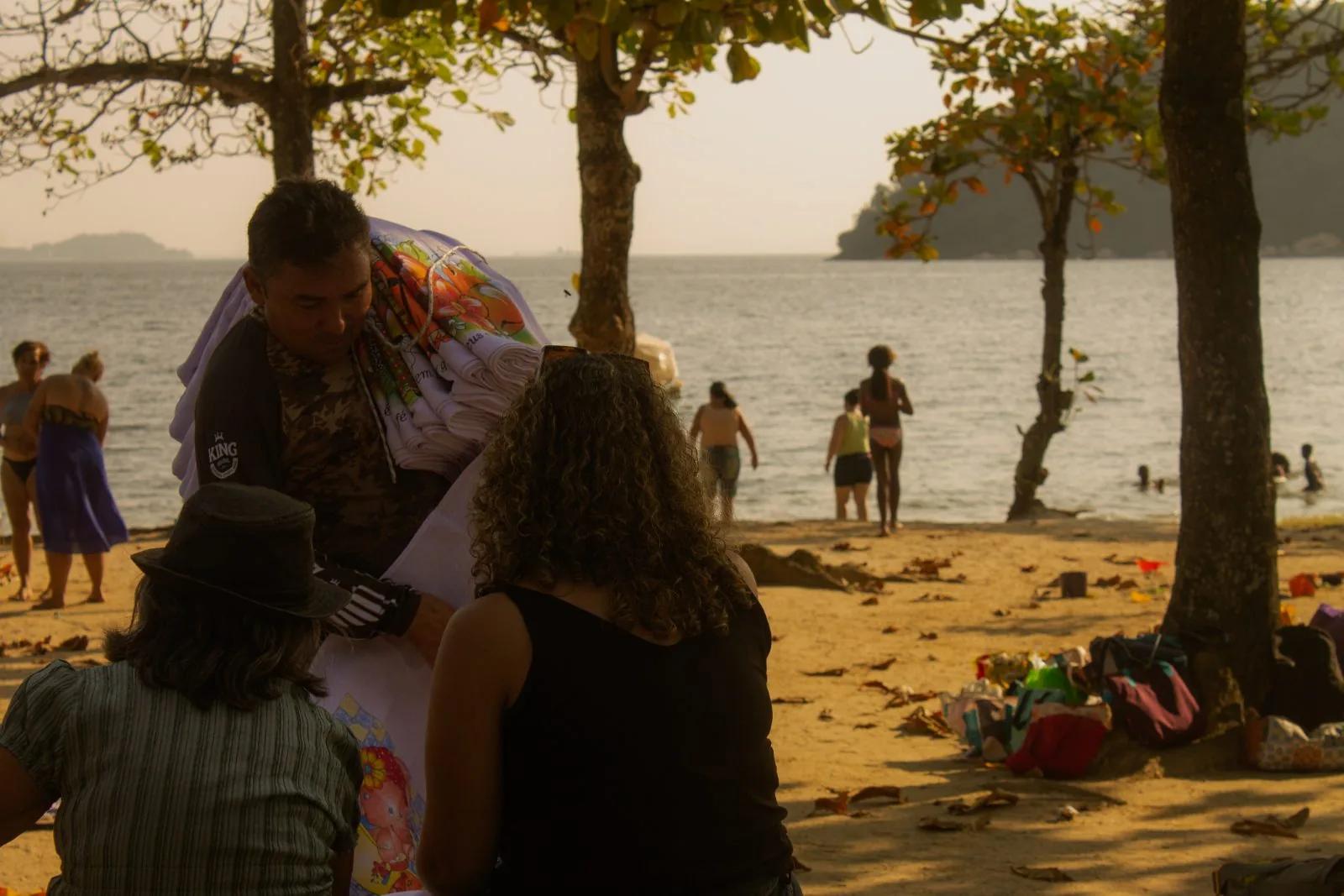 Roda de pessoas de costas para a praia