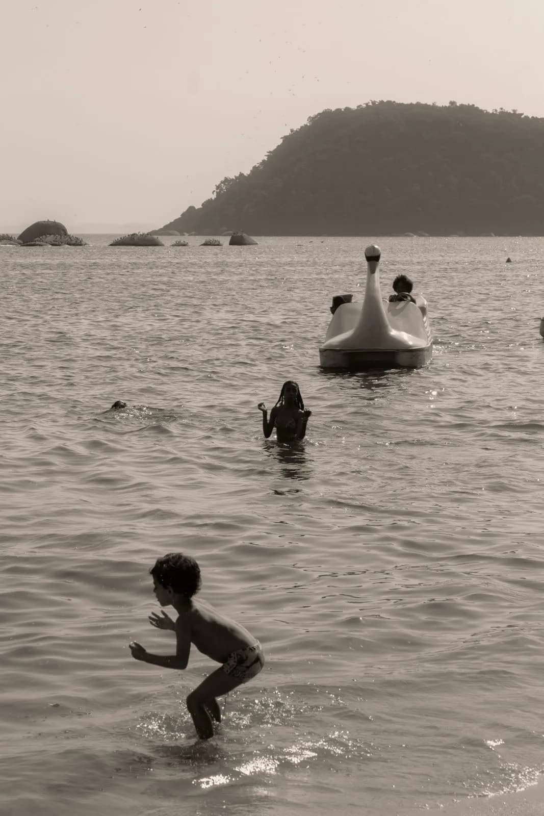 Crianças na água e pedalinho de cisne