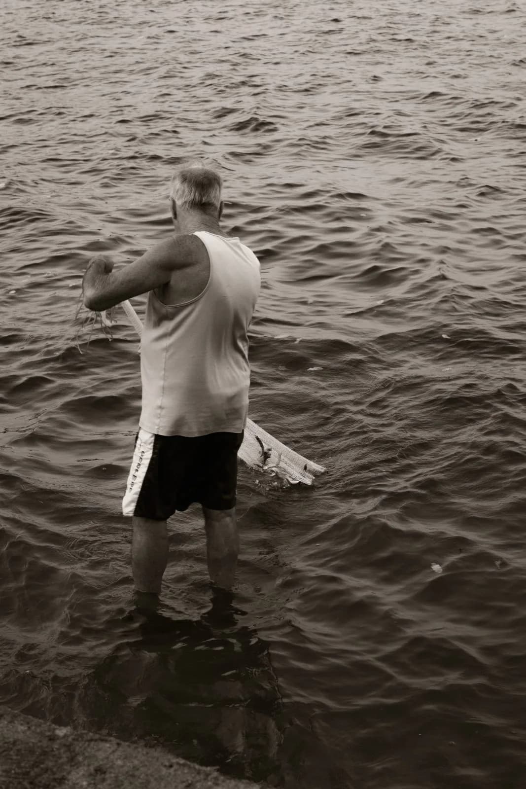 Pescador recolhendo dentro da água